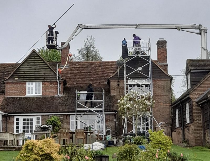 The Moss Cleaners using cherry picker and scaffolding to clean roof safely and professionally in Banstead, Surrey